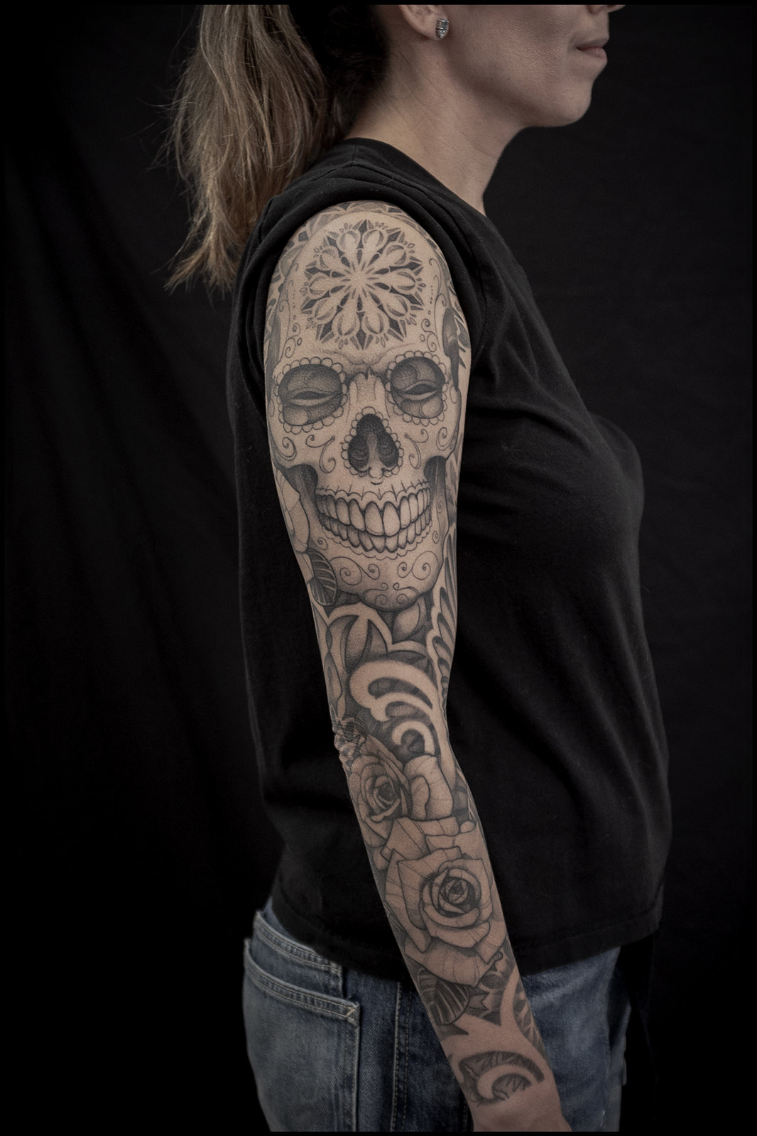 Woman with geometric sleeve tattoo featuring a skull by Adam LoRusso