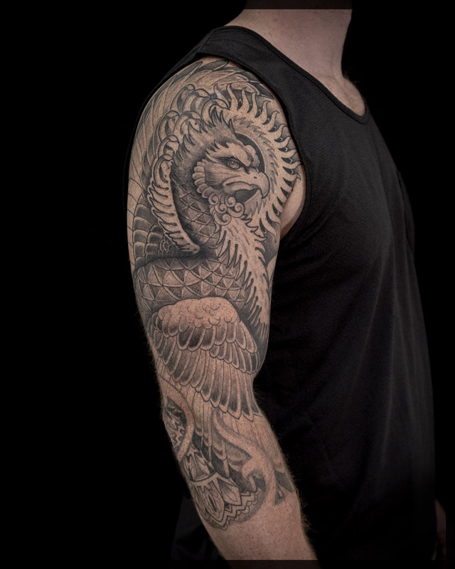 Intense black and gray pheonix tattoo sleeve on a mans arm