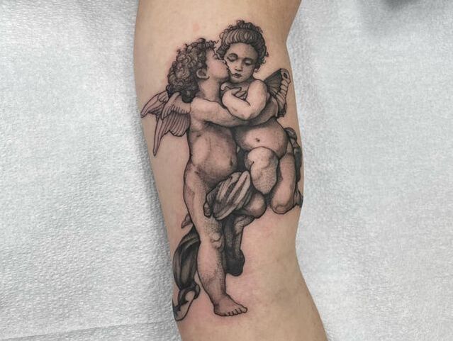 A fine line single needle tattoo of two cherubs, angels in black dotwork